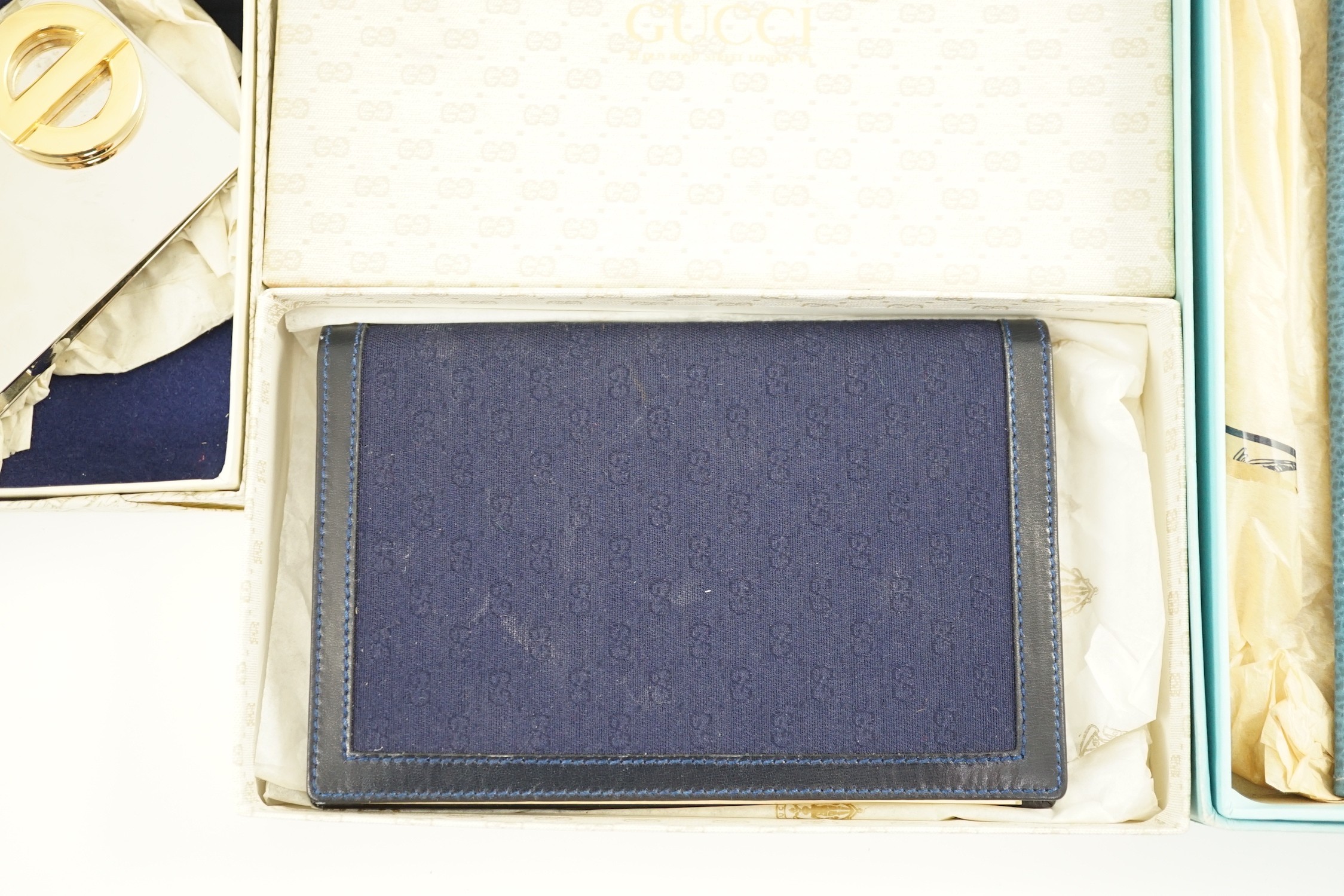 A Gucci blue leather address book, a Smythson leather travel wallet and a Christian Dior desk clip, all boxed.